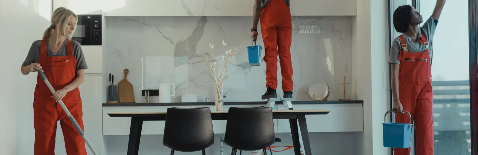 Fizzy Cleaning team mopping and wiping glass in a modern Auckland dining room