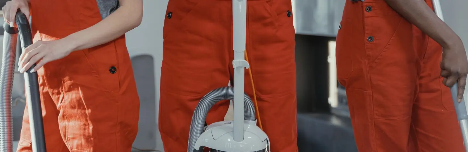 Cleaners in uniform holding vacuum and mop — the Fizzy Cleaning vision and mission